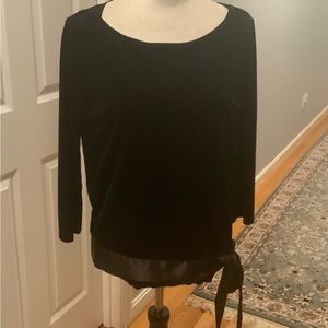 Like new a woman’s velvet like top in black with satin and side bow
